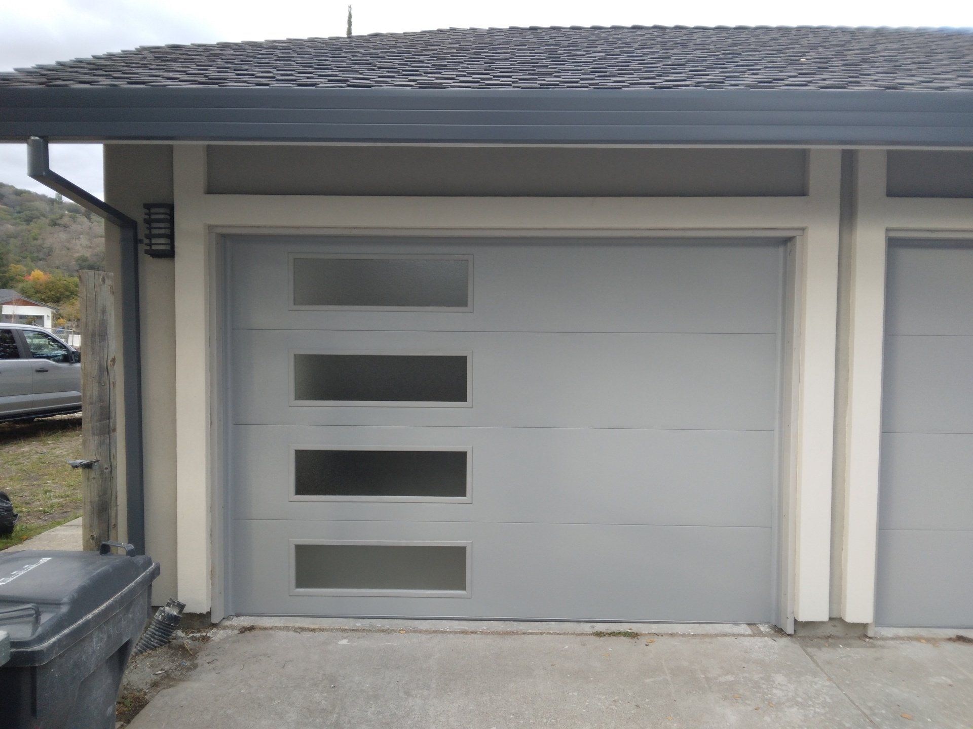 The left side of a double glass garage door installation in the Greater Bay area by Garage Door Excellence