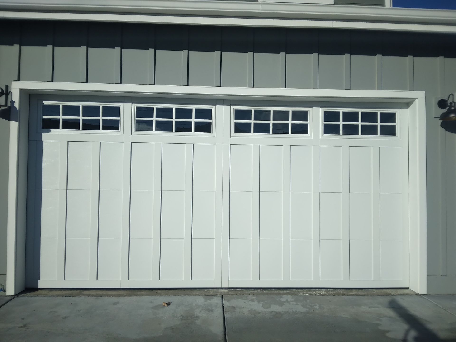 A white garage door with a lot of windows on it