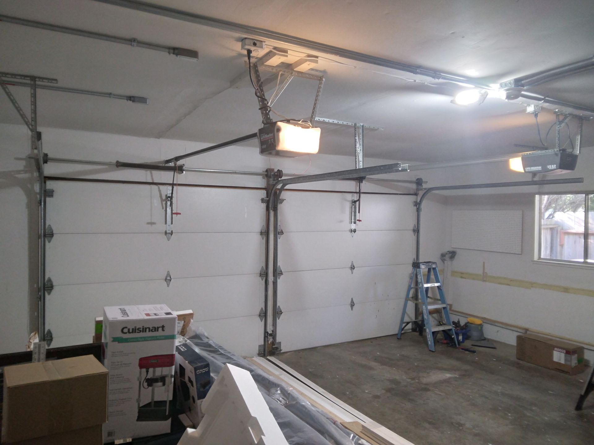 A garage with a garage door open and a ladder.