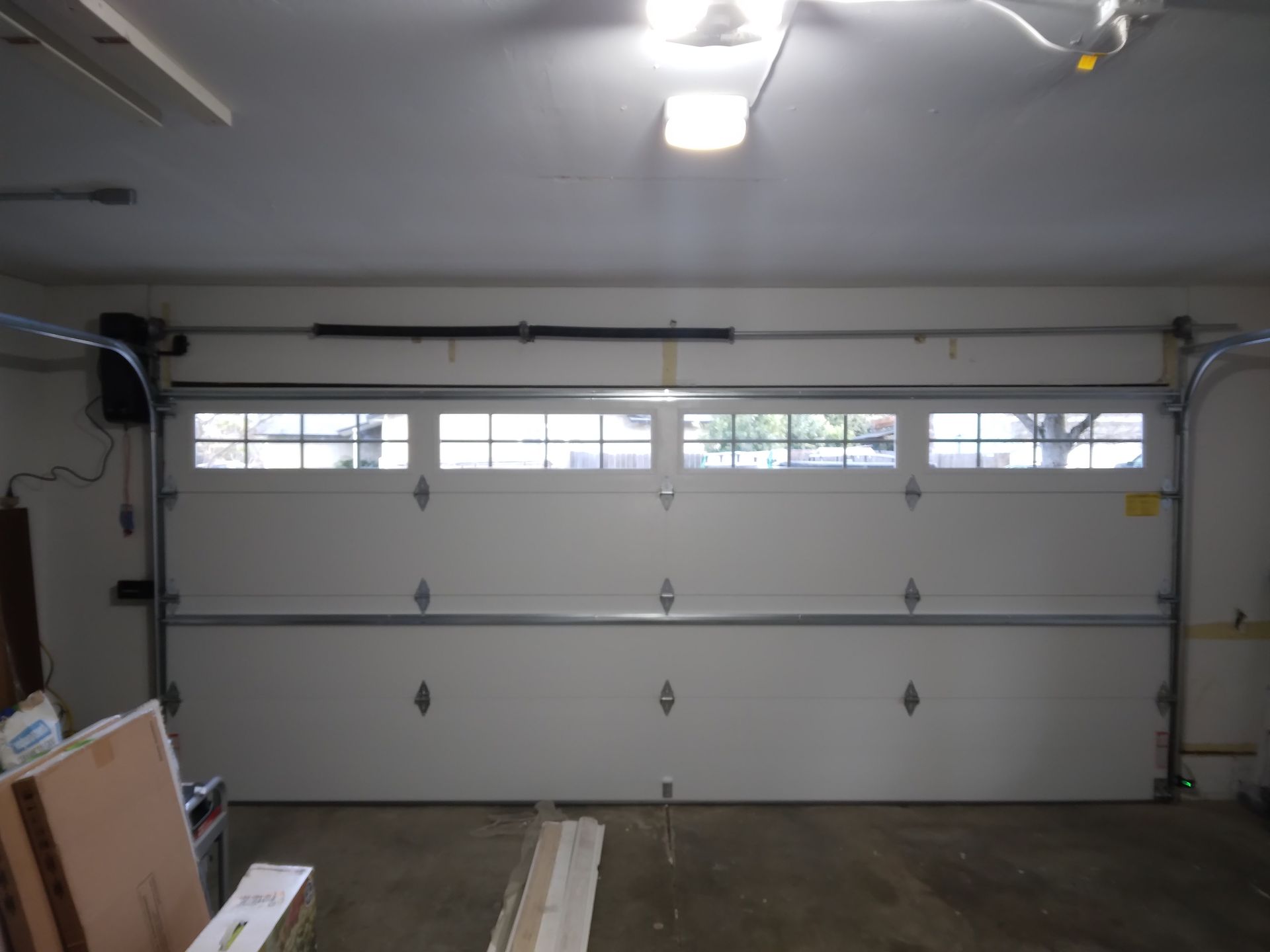 A garage with a white garage door and a ceiling fan
