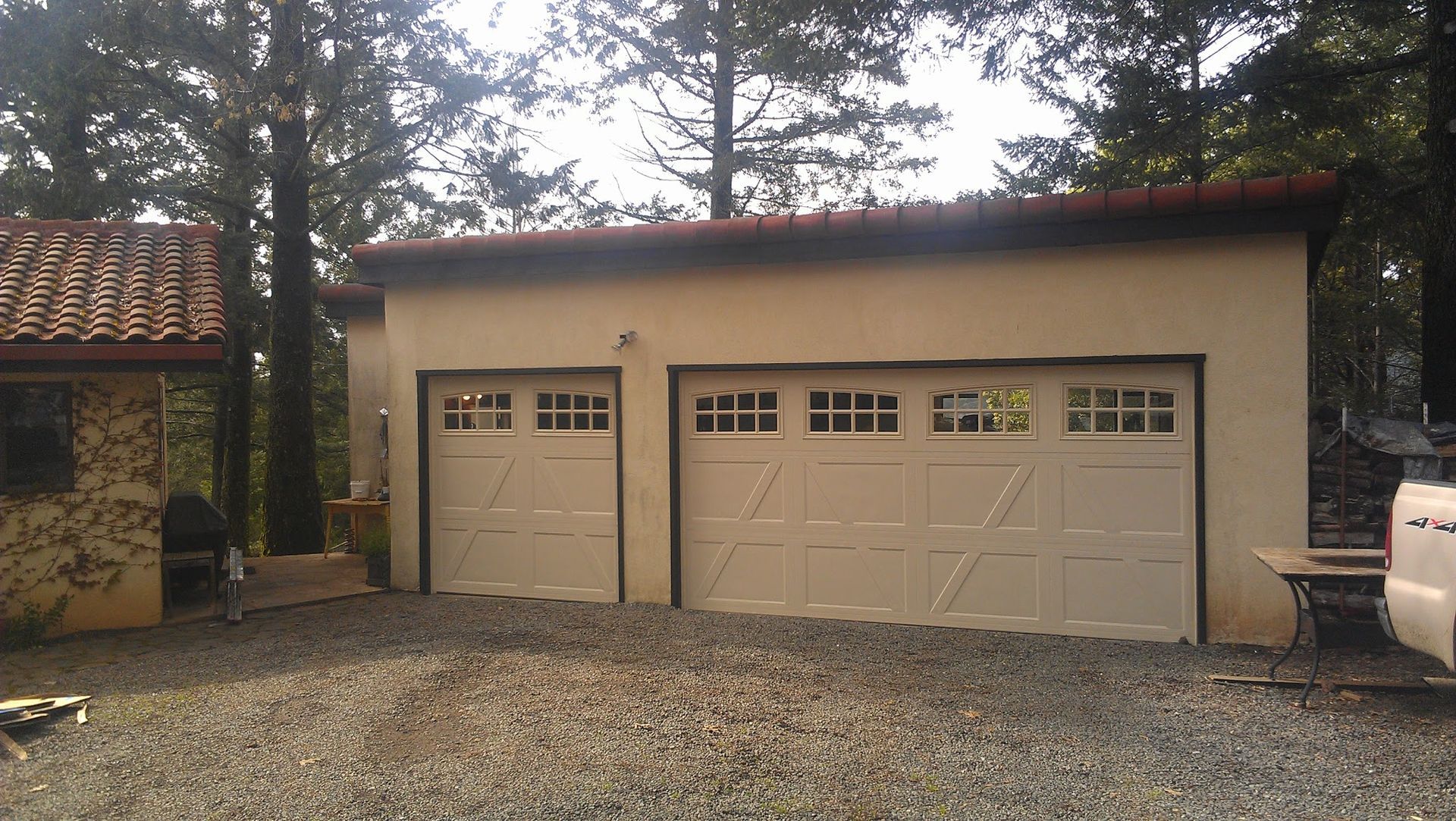 A garage with three doors and a red roof