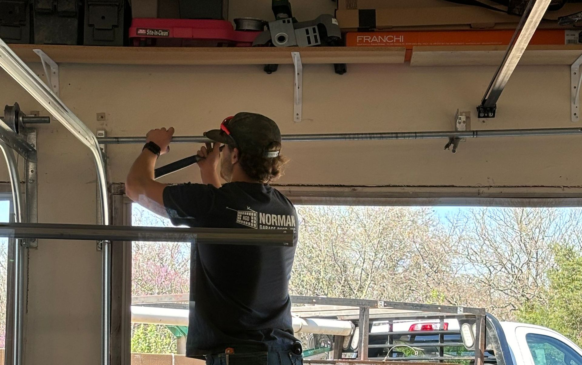 Man inspecting automatic garage door during professional garage door service at home.