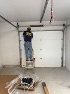 A man is working on a garage door.