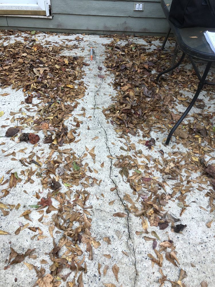 A pile of leaves on the ground next to a table and chair.