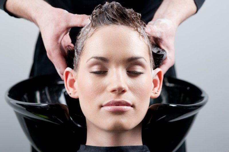Eine Frau lässt sich in einem Salon die Haare waschen