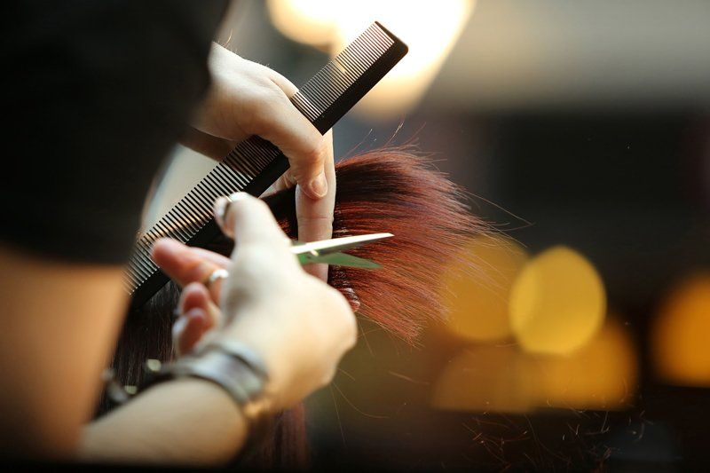 Eine Frau lässt sich beim Friseur die Haare schneiden