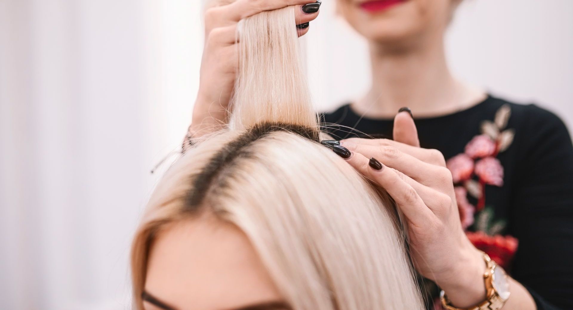 Eine Frau lässt sich in einem Salon von einem Friseur die Haare machen.