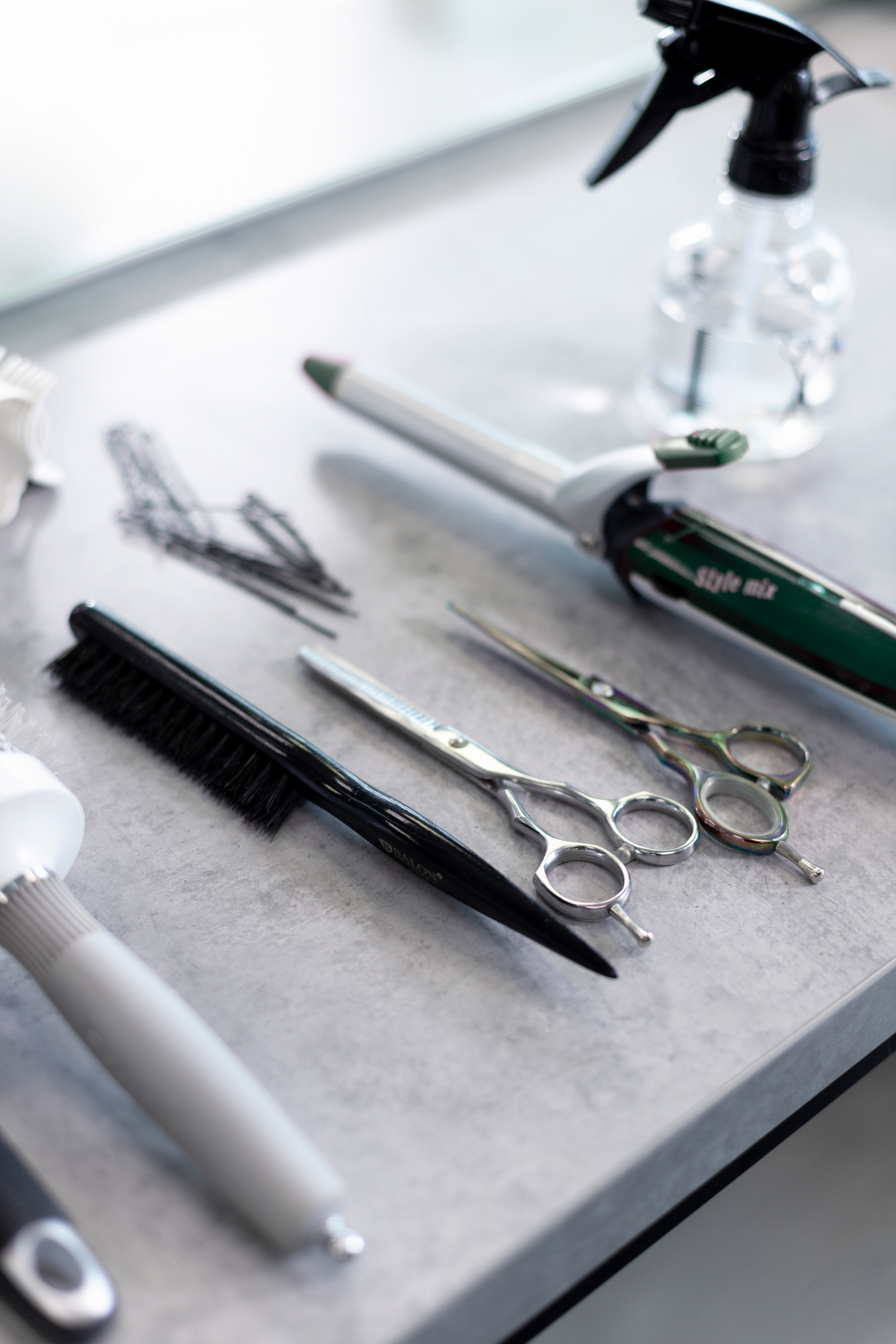 Ein Tisch mit Scheren, Kämmen und einer Sprühflasche darauf.