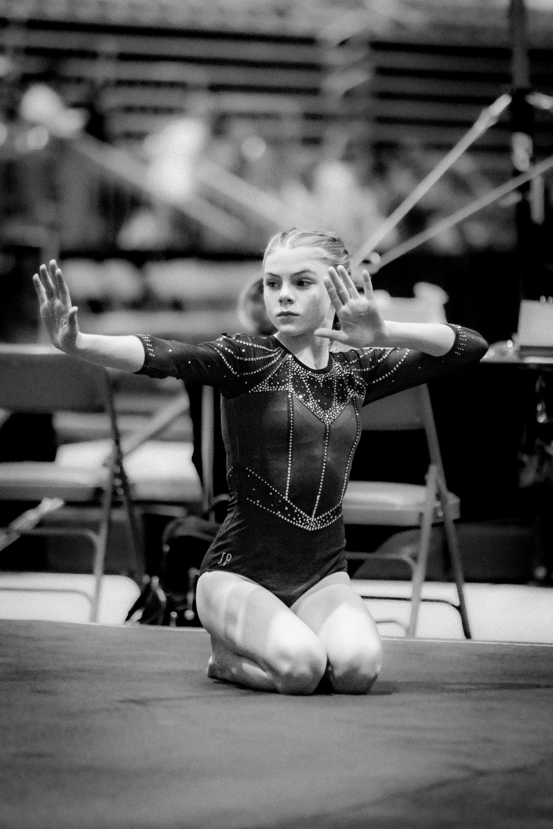 A black and white photo of a gymnast kneeling on the floor