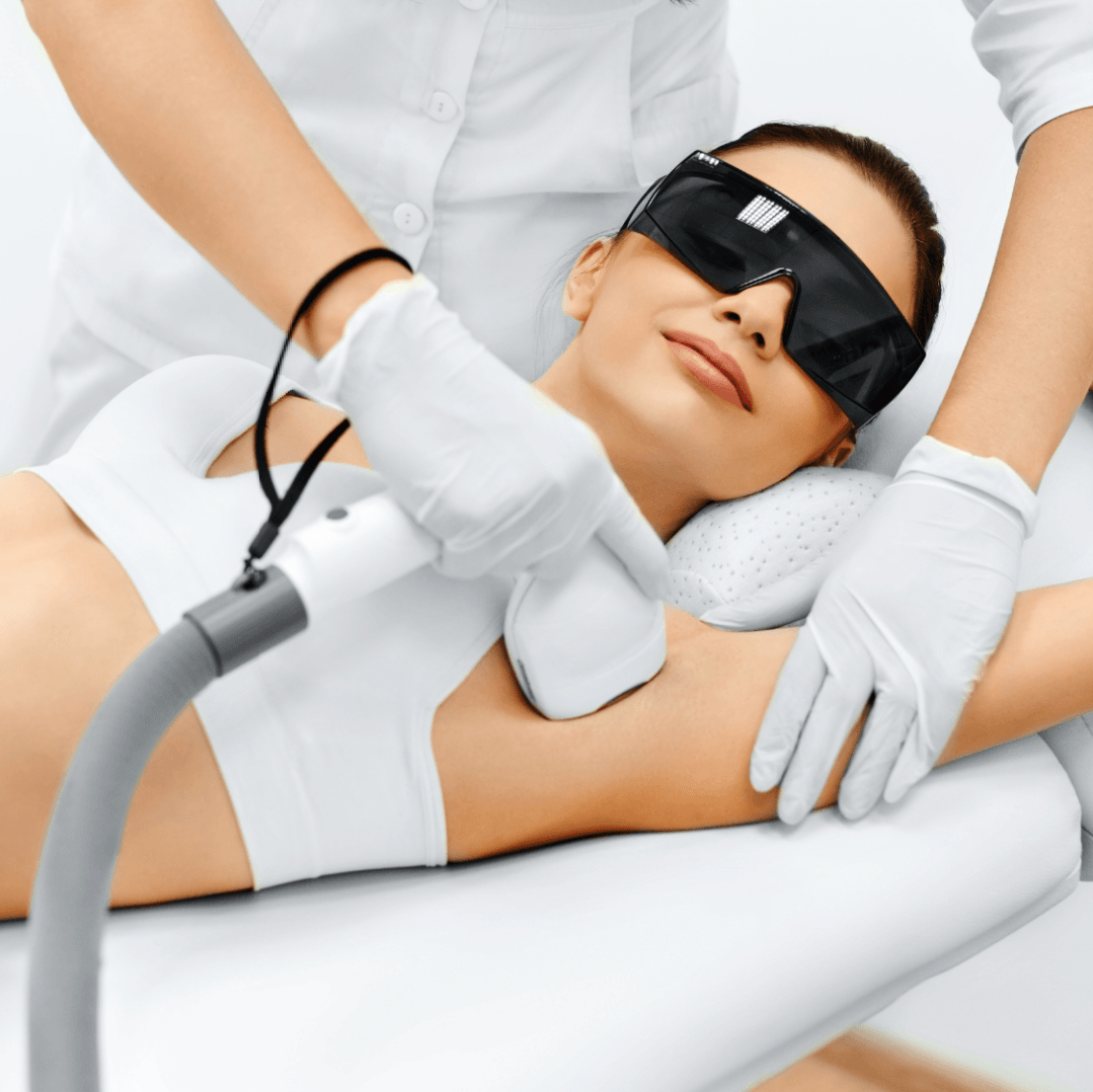 Een vrouw met een zonnebril krijgt een laserbehandeling op haar oksel
