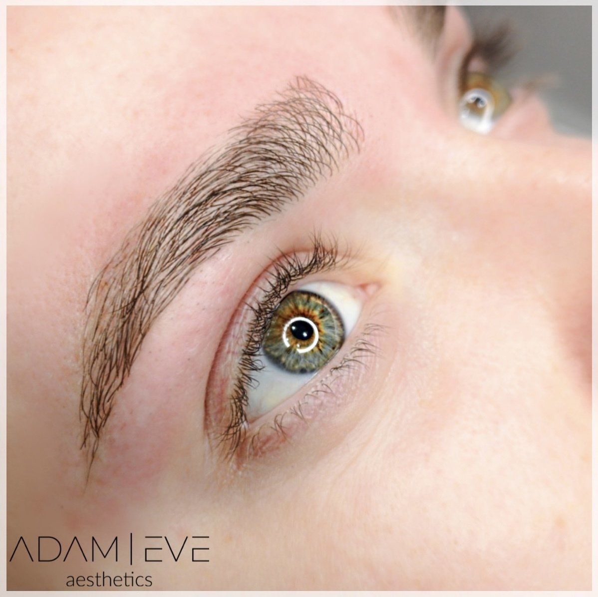 Een close-up van het oog van een vrouw met de esthetiek van Adam Eve op de onderkant geschreven