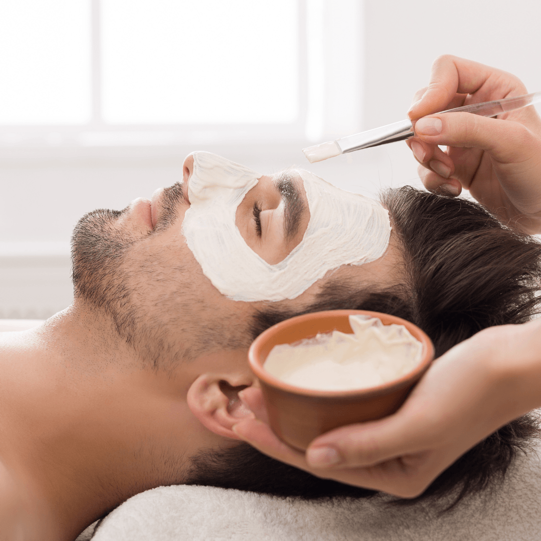 Een man krijgt een wit masker op zijn gezicht
