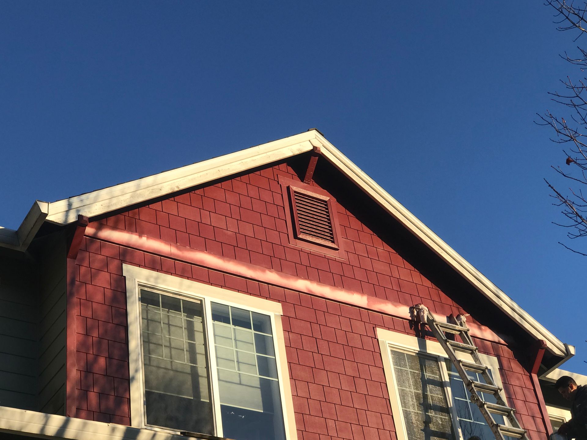 A red house with a ladder on the side of it