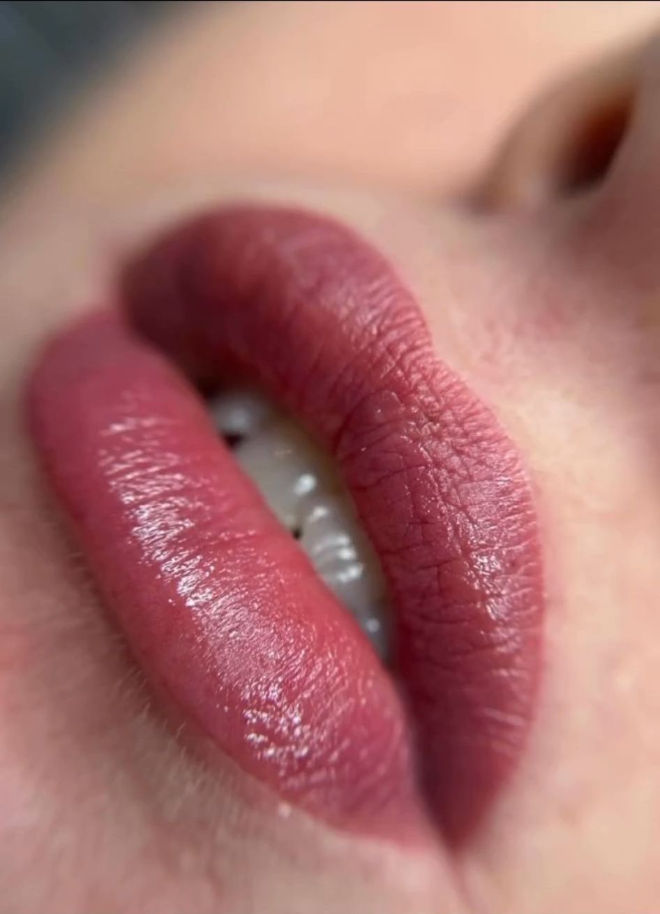 Un primo piano delle labbra di una donna con rossetto rosso.