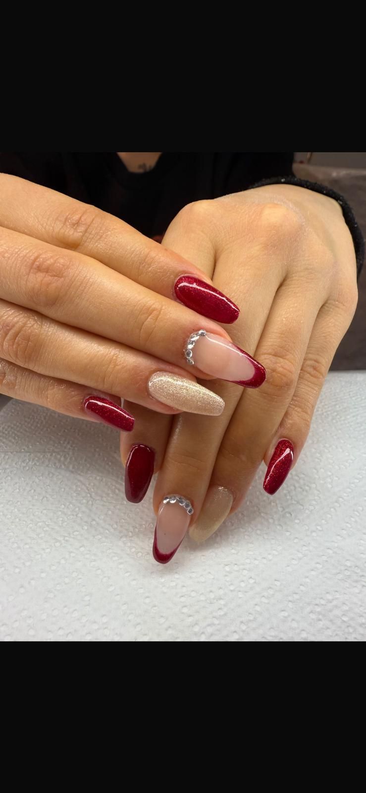 Un primo piano delle unghie di una donna con unghie rosse e bianche.