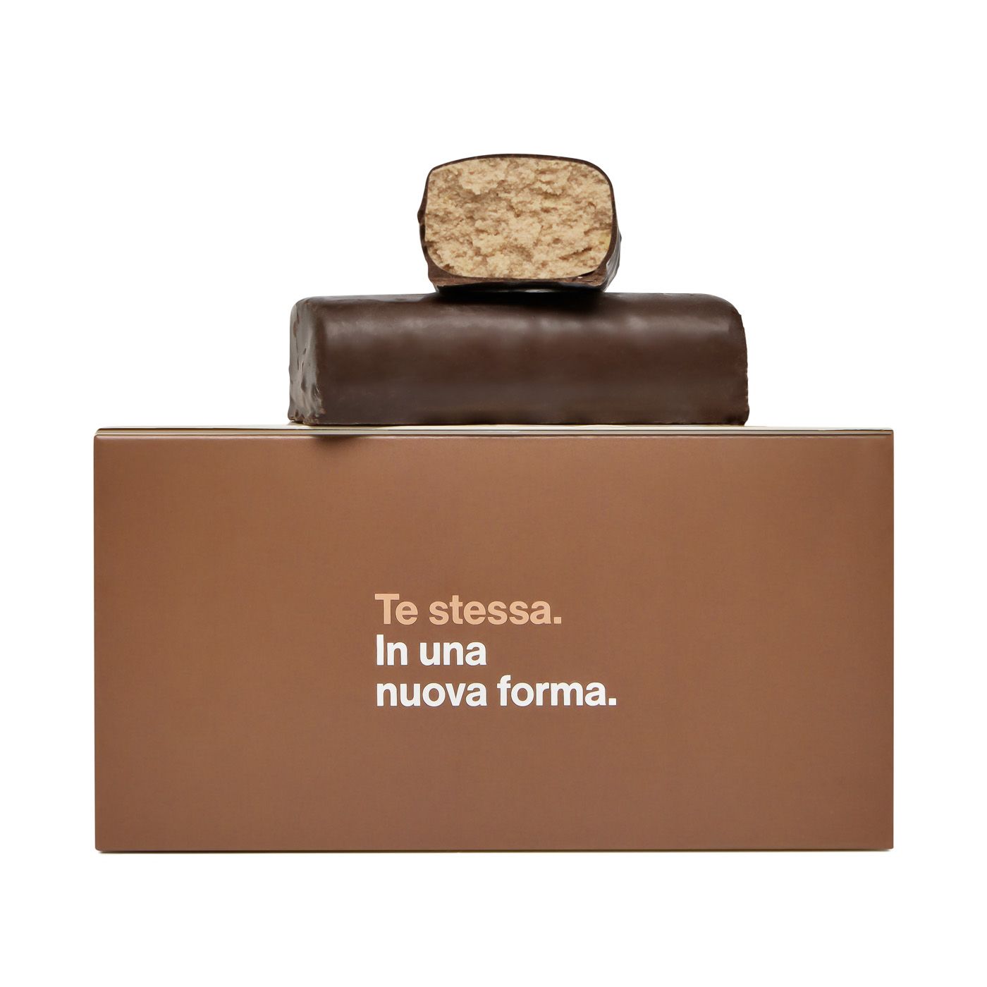 Due tavolette di cioccolato sono impilate una sull'altra su una scatola marrone che dice te stessa in una nuova forma.