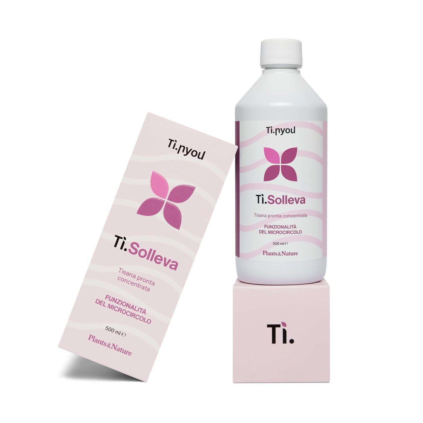 Una bottiglia di ti solleva è posata sopra una scatola rosa.