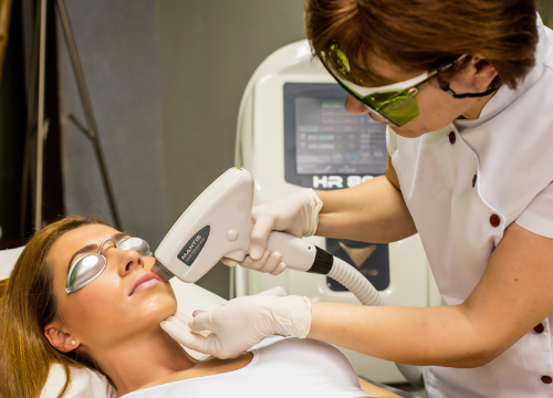 Una donna sta ricevendo un trattamento di depilazione laser sul viso.