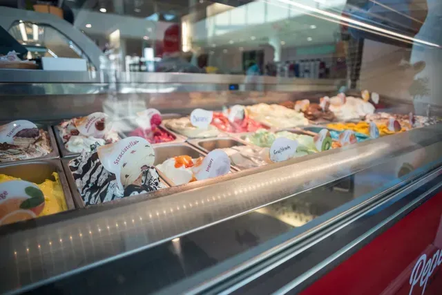 A display case filled with lots of different flavors of ice cream.