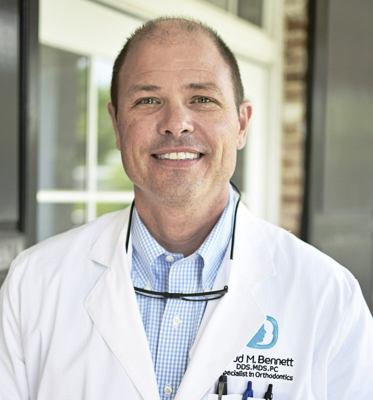 A man wearing a white lab coat with the name jd millernett on it