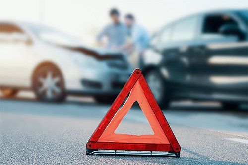 Warning Triangle with Car Accident Background — Beverly Hills, CA — Richard D. Hoffman Law Offices