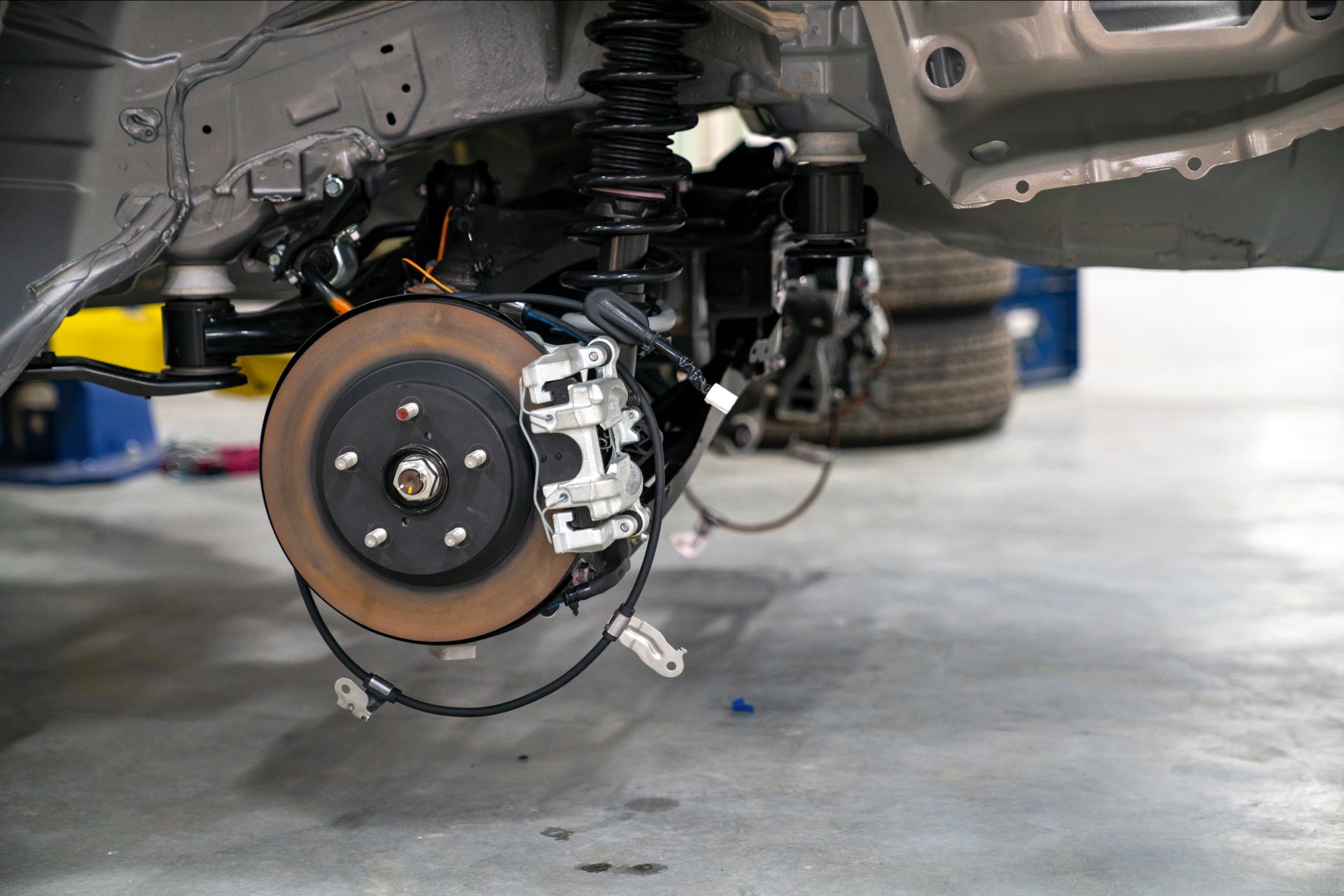 A close up of a car 's brake system in a garage.