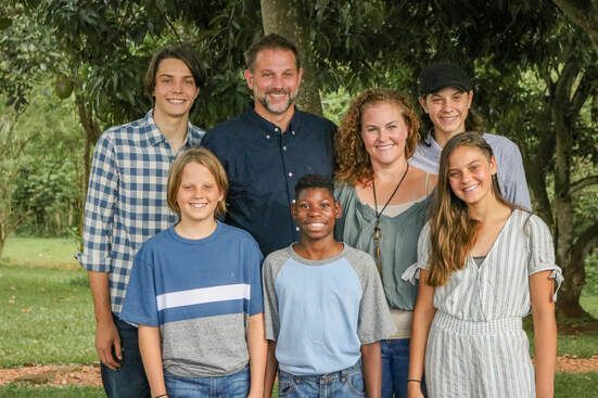 A group of people are posing for a picture in front of a tree.