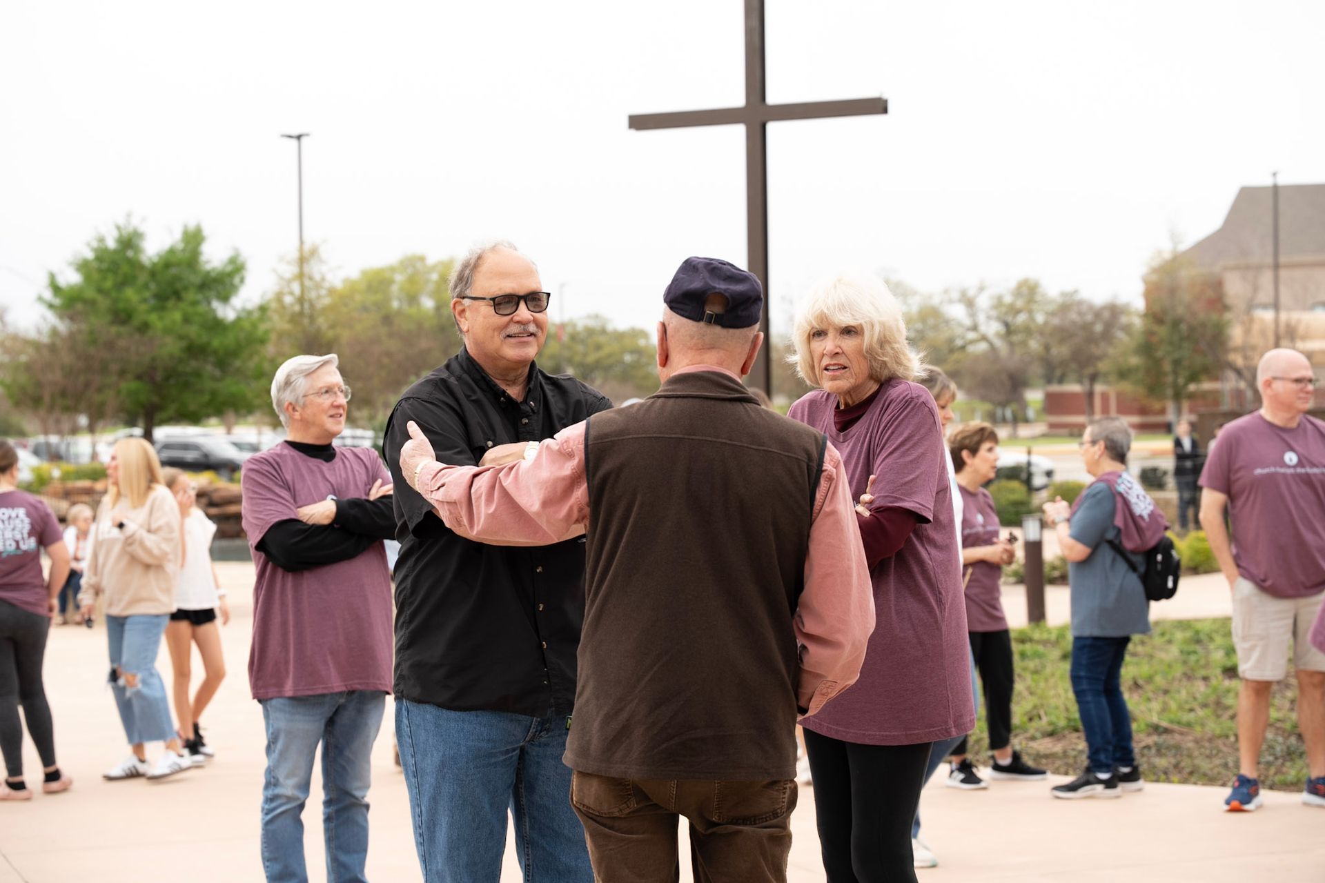 A group of men in white shirts are standing in front of a church.