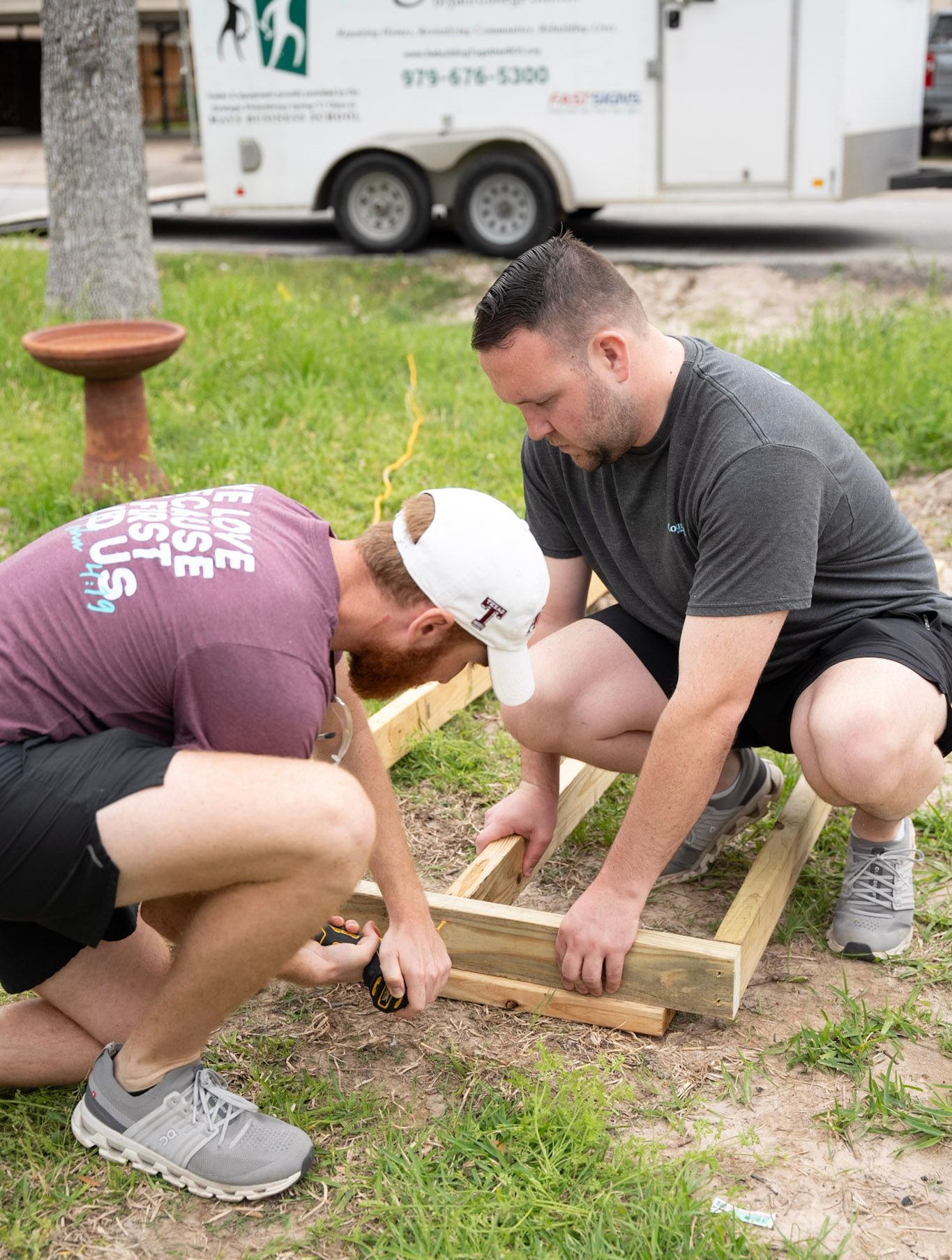 A group of young men are working on a wooden structure.