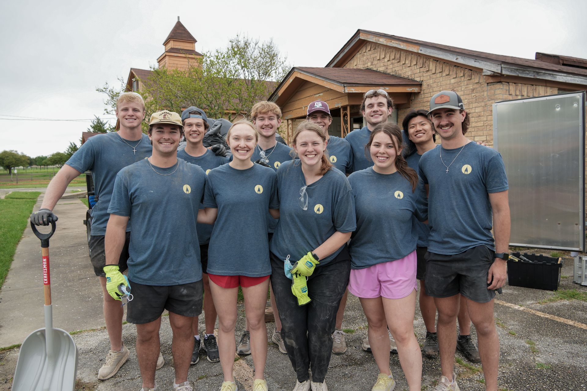 A group of people are posing for a picture in front of a building.