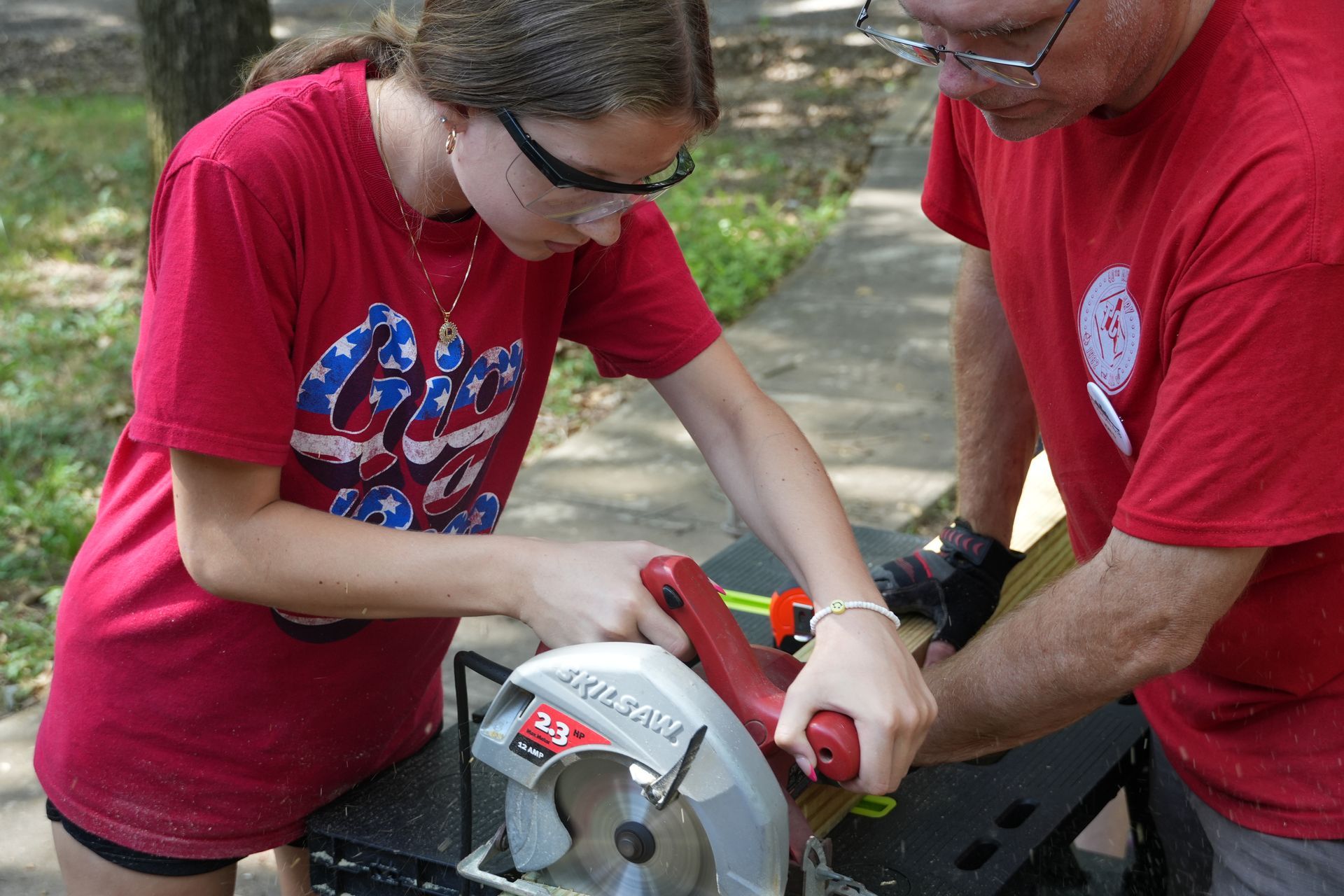 A man and a girl are working on a circular saw