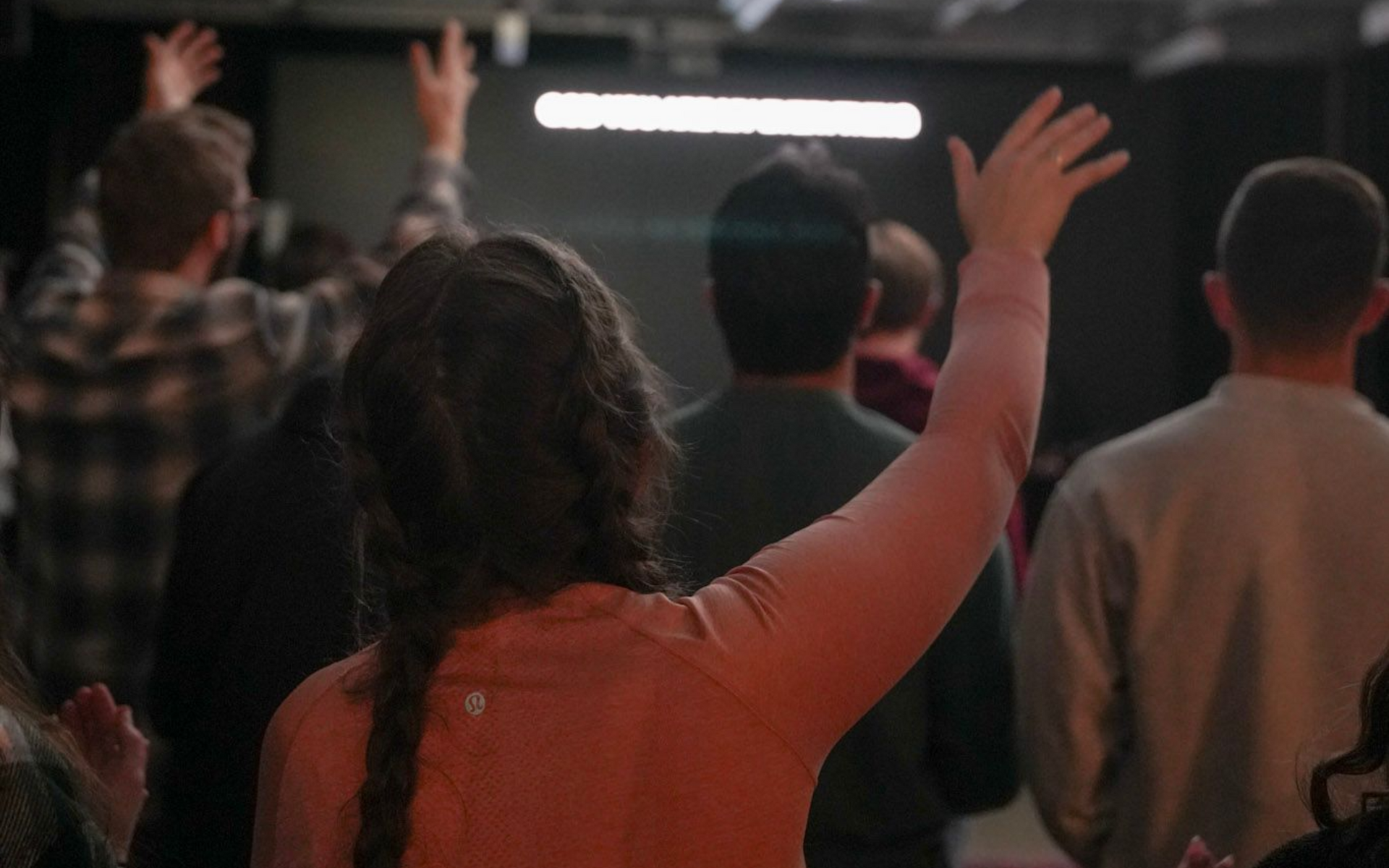 A group of young people are singing and worshipping.