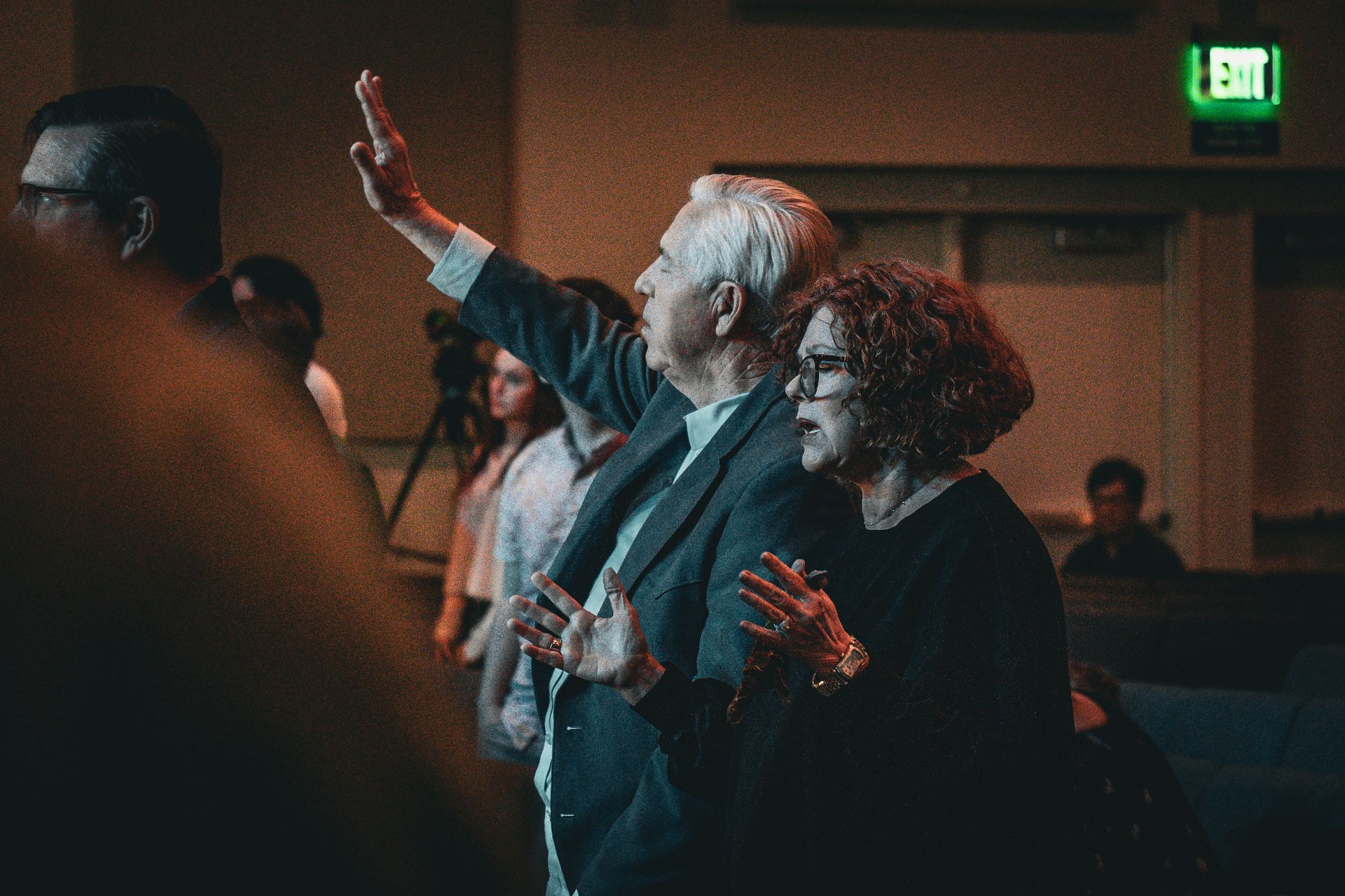A man and a woman are standing next to each other in a dark room.