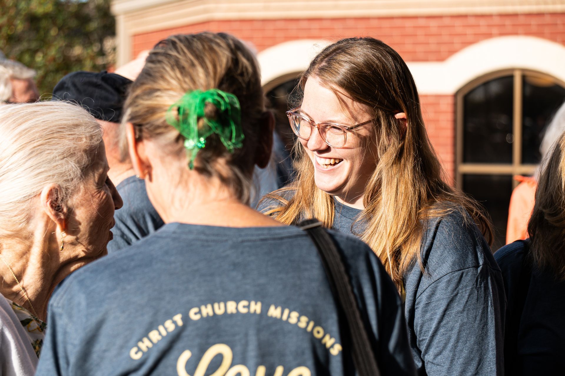 A woman wearing a shirt that says ' christ church missions ' on it