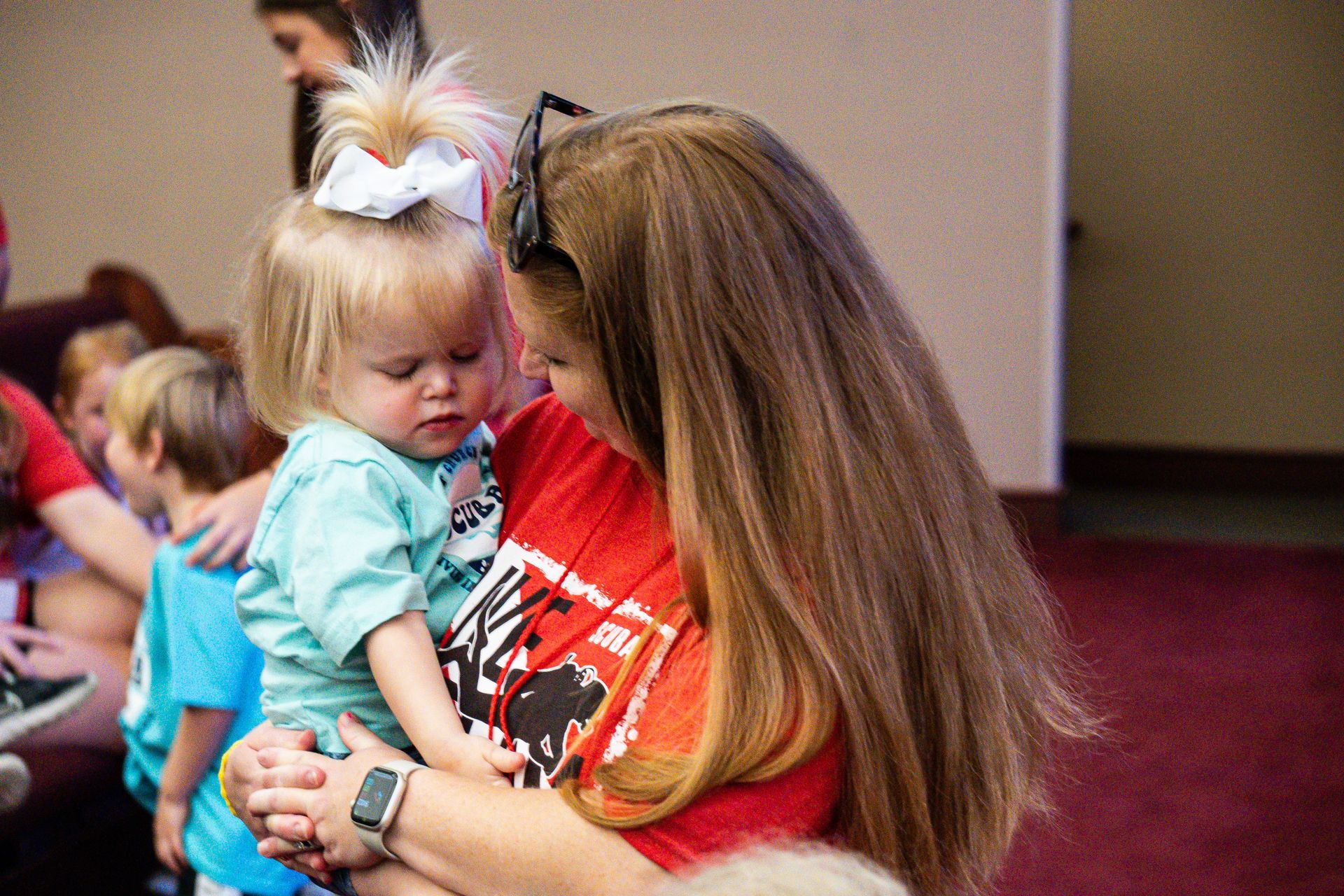 A woman is holding a little girl in her arms.