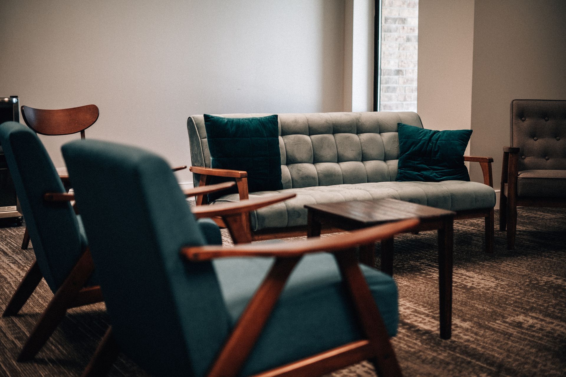 A living room with a couch , chairs , and a table.