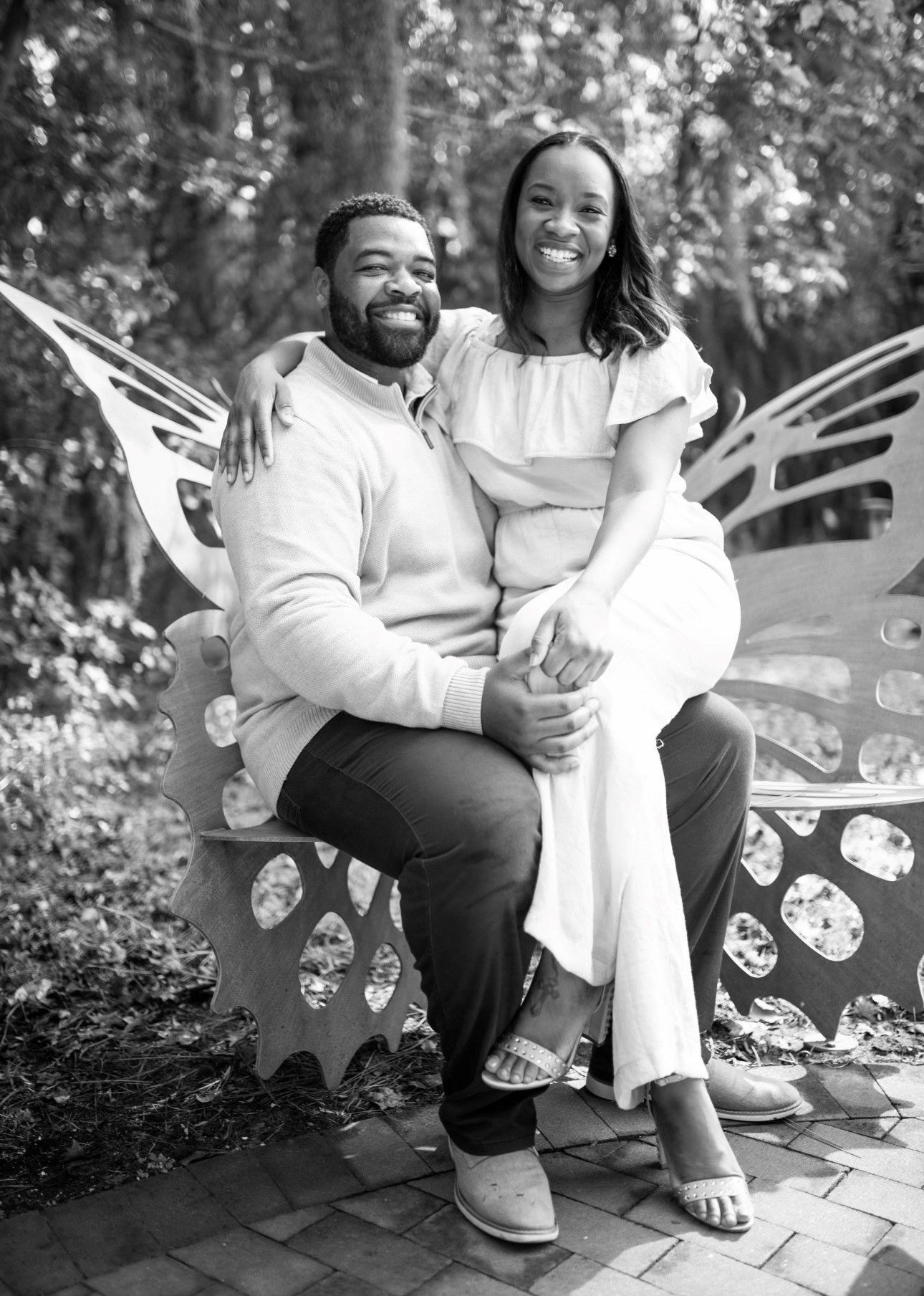 A man is holding a woman in his arms while sitting on a bench.