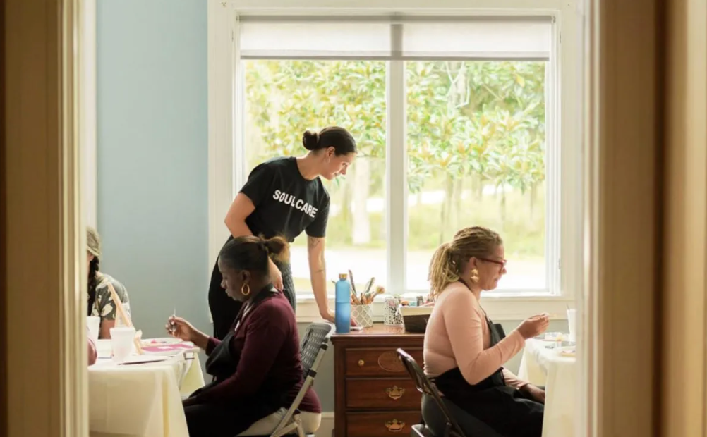 A group of women are sitting at tables in a room.