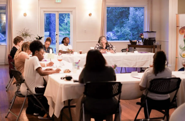 A group of people are sitting around a table in a room.