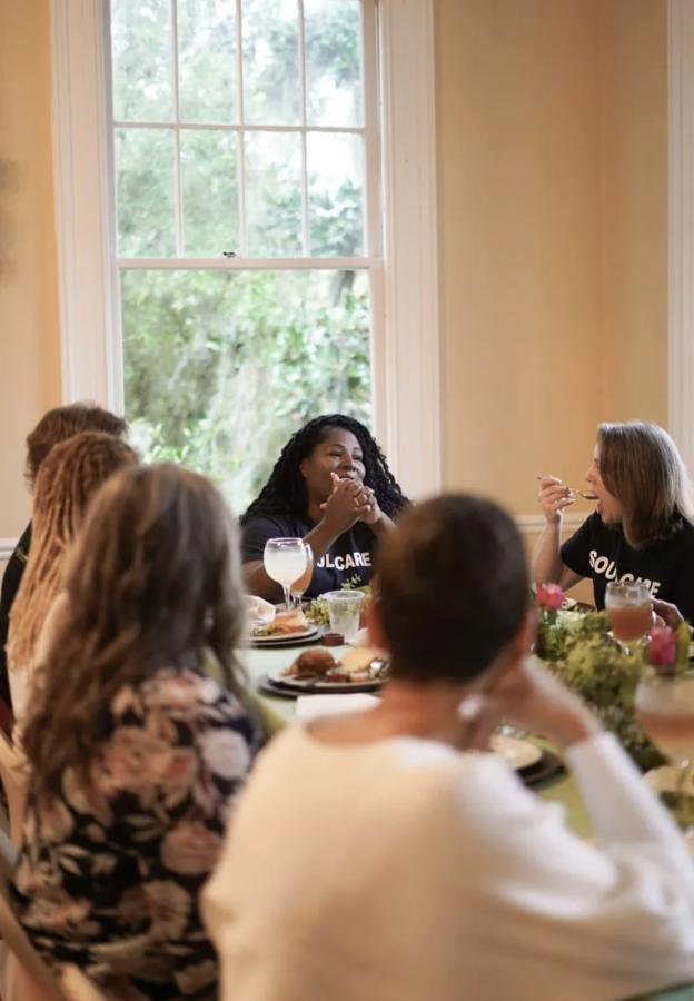 A group of people are sitting around a table eating food.