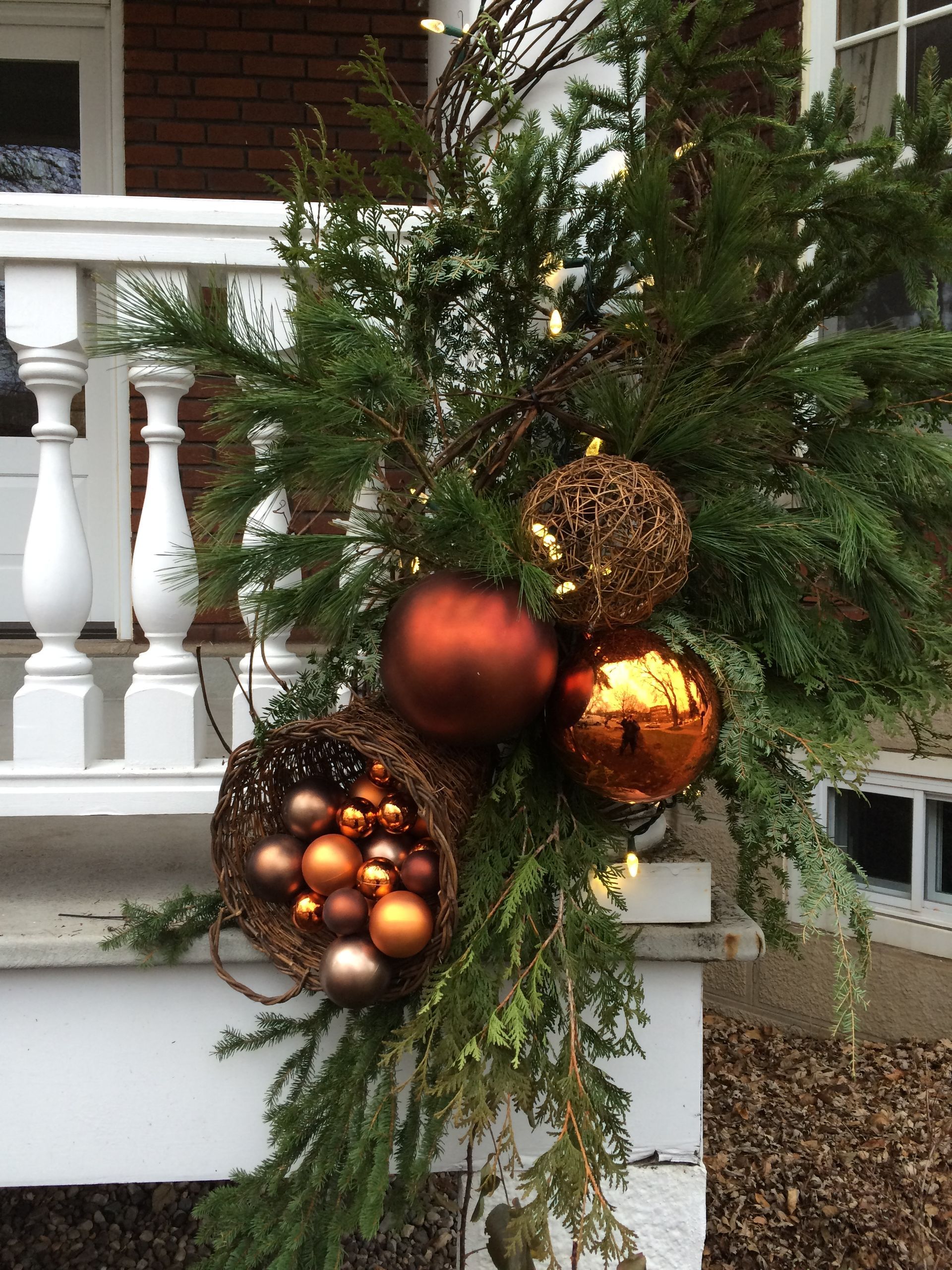 Un porche décoré pour Noël avec un panier rempli d'ornements