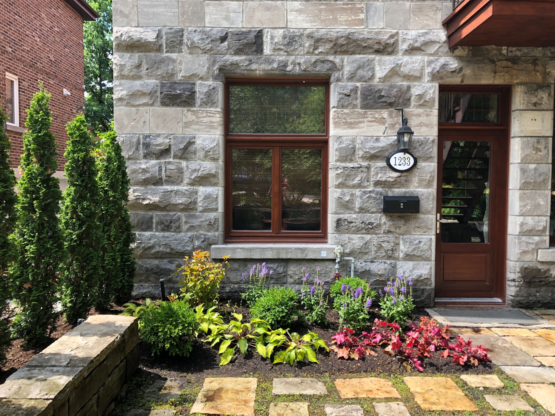 La façade d'une maison en brique avec un jardin devant.