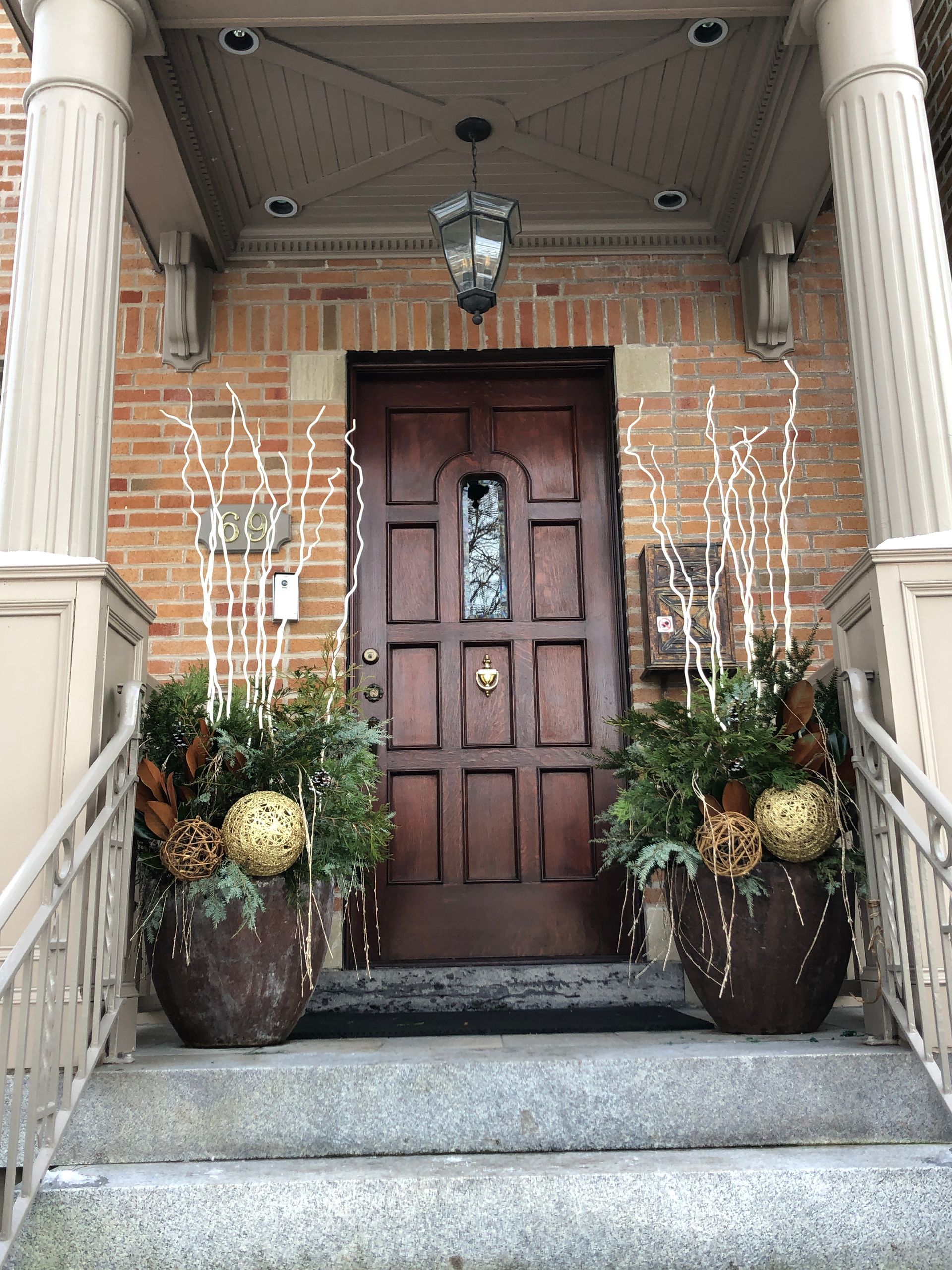 A brick building with a wooden door decorated for christmas