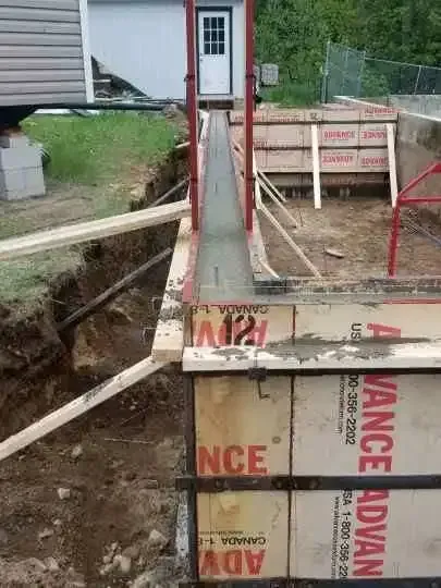 A concrete wall is being built in front of a house.