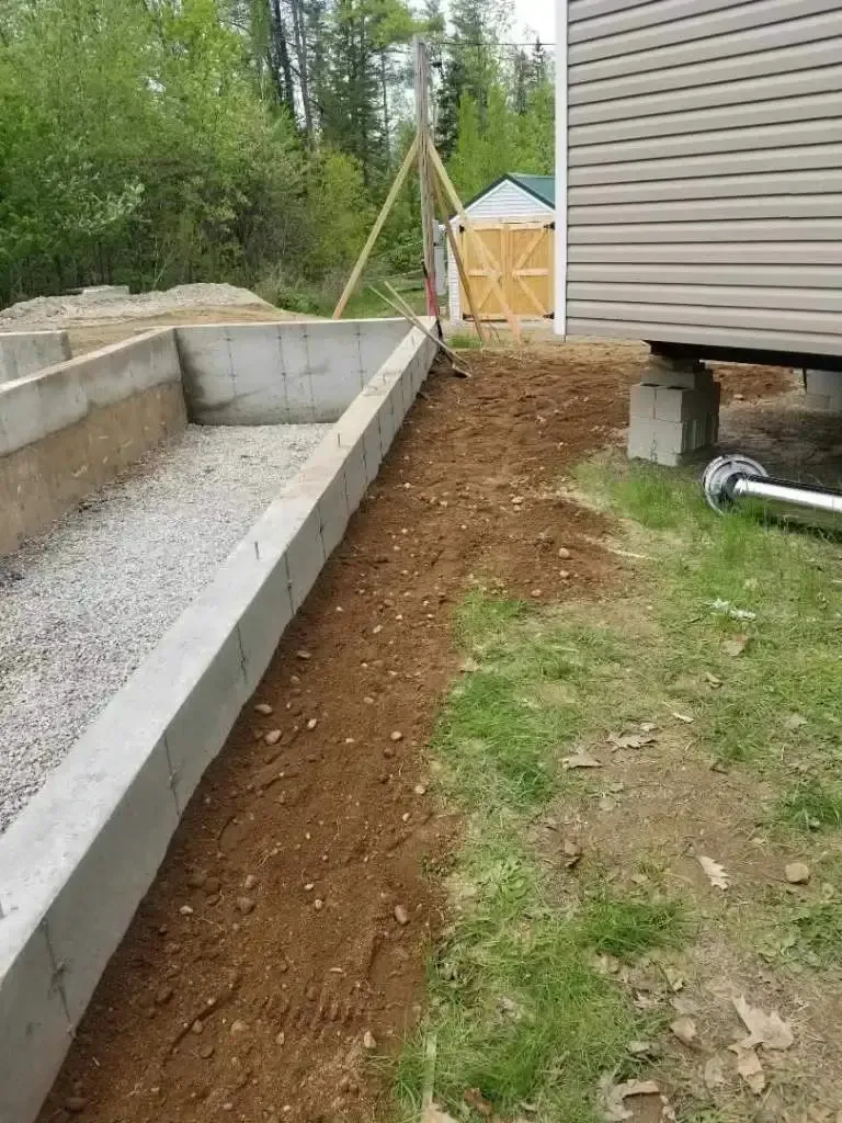 A concrete foundation is being built next to a house.