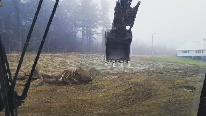 A large excavator is digging a hole in a field.