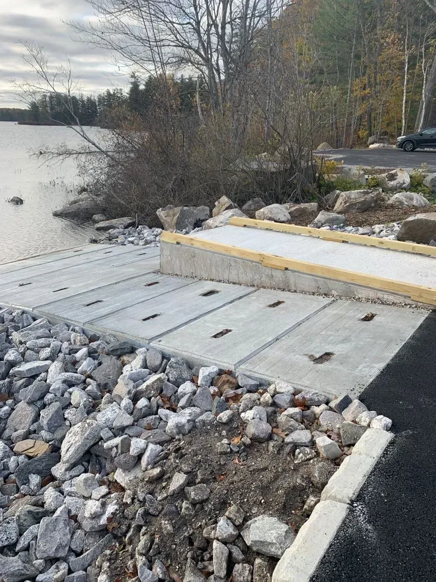 A concrete ramp is being built next to a body of water.