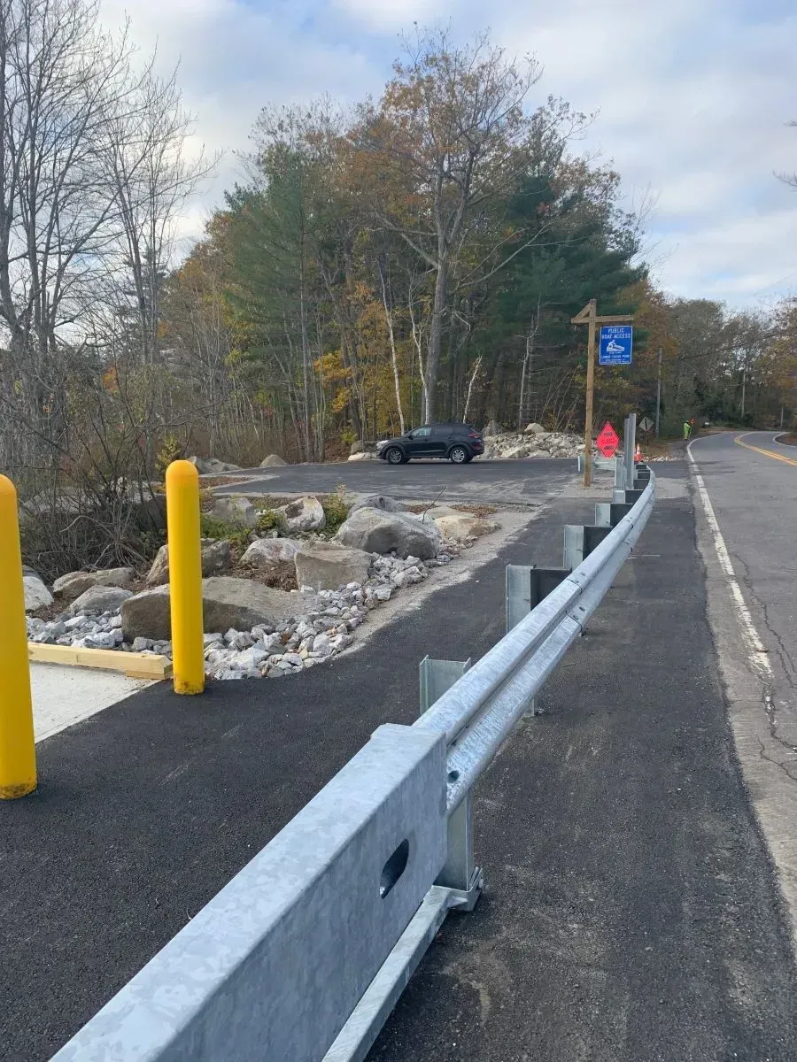 A car is parked on the side of the road next to a fence.