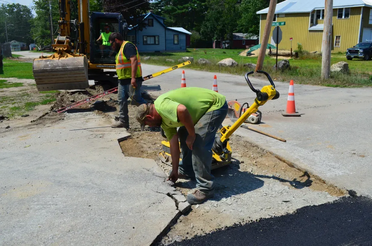 A group of construction workers are working on a road