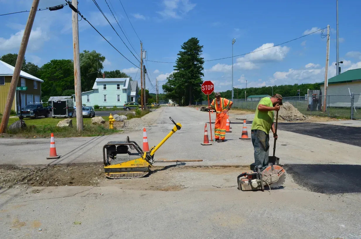 A group of construction workers are working on a road.